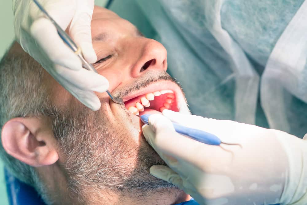 Patient getting plaque scraped off teeth