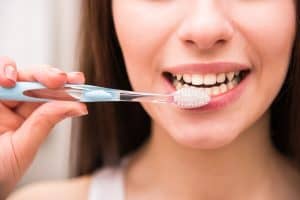 Lady brushing with fluoride toothpaste